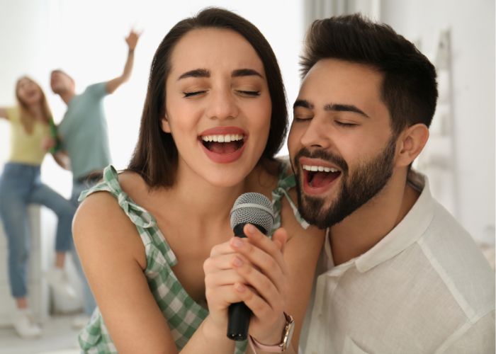 Happy Couple Singing Into One Microphone
