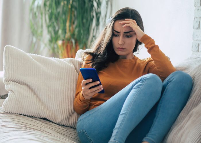 Frustrated Woman Looking At Her Phone