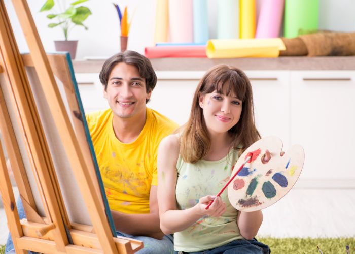 Couple Painting Together With Canvas And Art Supplies At Home