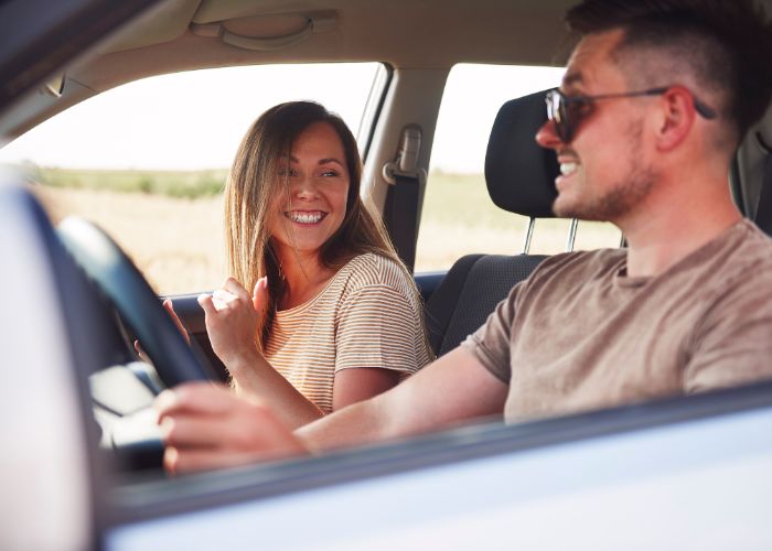 Smiling Couple Talking Inside A Car During A Relaxed Road Trip.