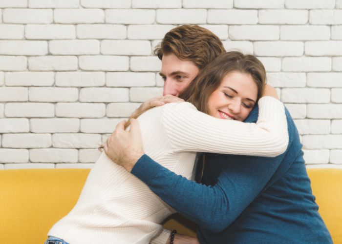 Couple Sharing A Warm Hug And Offering Emotional Support At Home.