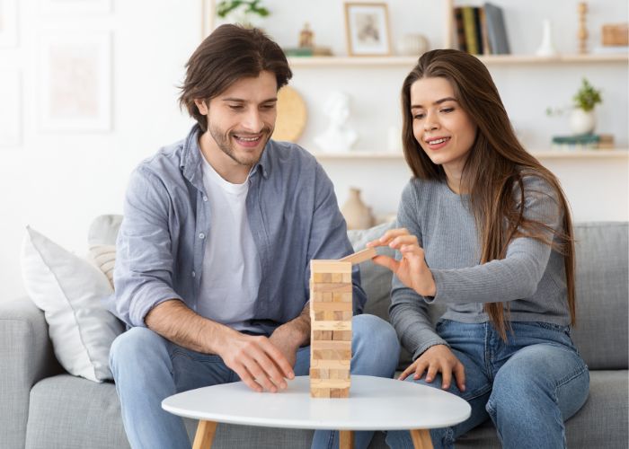 Man And Woman Playing Jenga At Living Room At Home