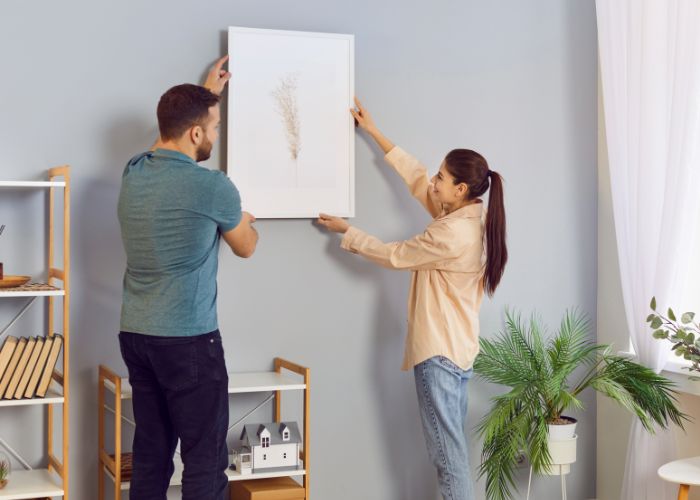 Couple Hanging Framed Wall Art In A Bright Living Room