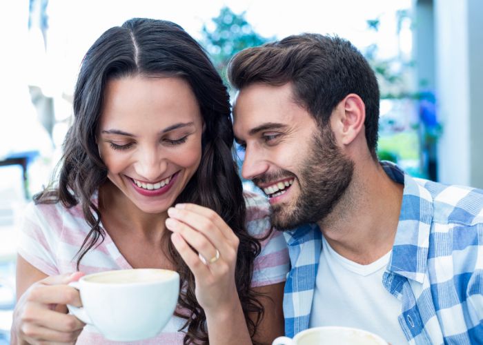 Smiling Couple Enjoying Coffee And A Lighthearted Moment Together.
