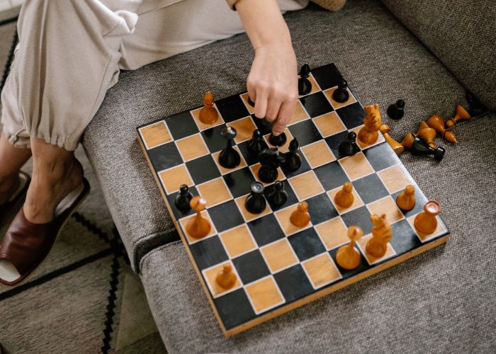 Close Up Of A Chessboard As A Person Moves A Piece During A Casual Game At Home.