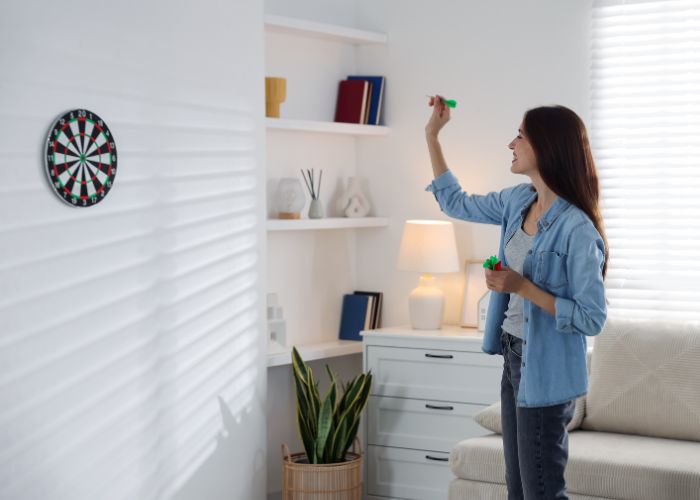 Woman Playing Darts At Home