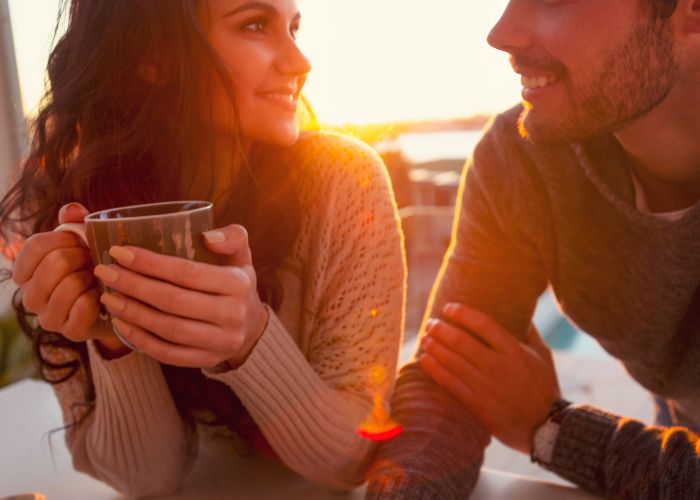 Young Couple Drinking Coffee At Sunrise Or Sunset