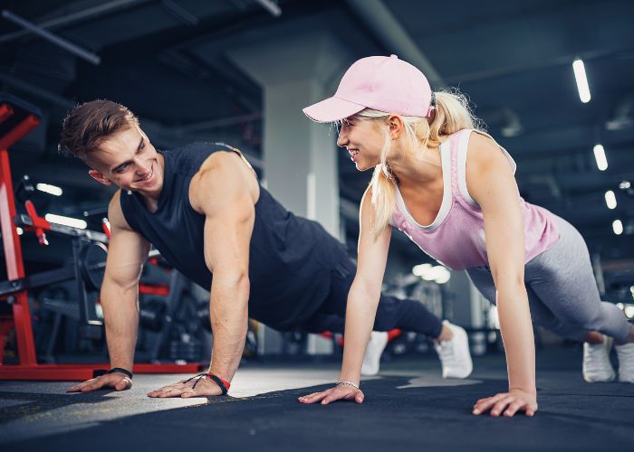 Couple Doing Push Ups Together At A Gym