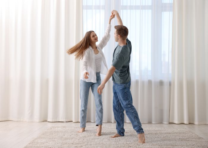 Happy Young Couple Dancing Together At Home