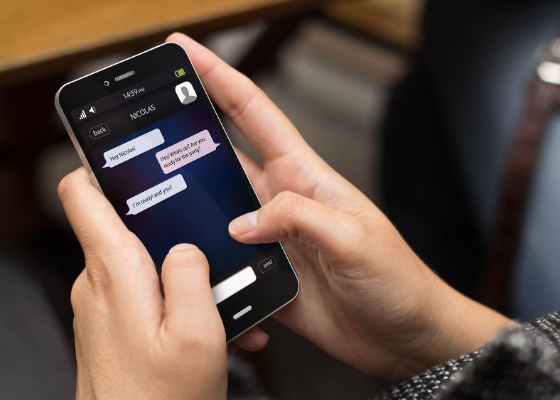 Person Secretly Texting On Smartphone