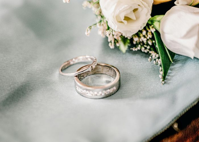 Wedding Rings Beside White Flowers