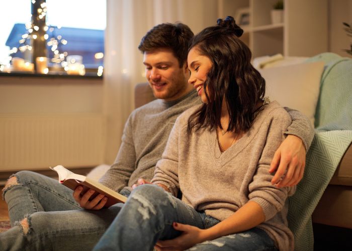 Couple Reading Book At Home