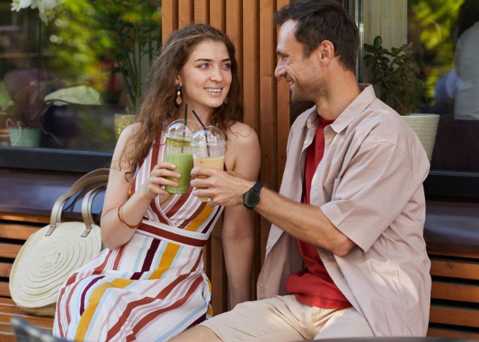 Couple Drinking Cocktails In Outdoor Cafe