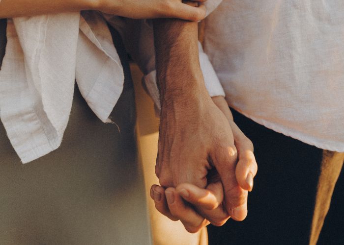 Couple Holding Hands Closely, Showing Warmth, Comfort, And Emotional Connection