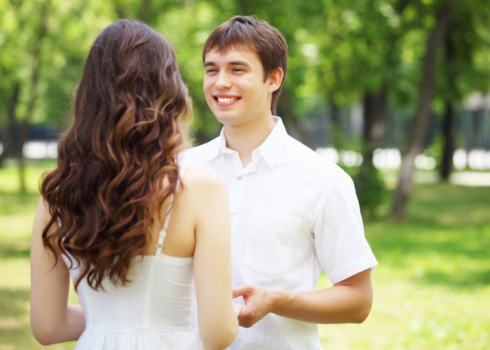 Happy Couple Holding Hands And Talking In A Sunny Park