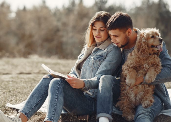 Happy Couple Looking At Photo Album On Lawn