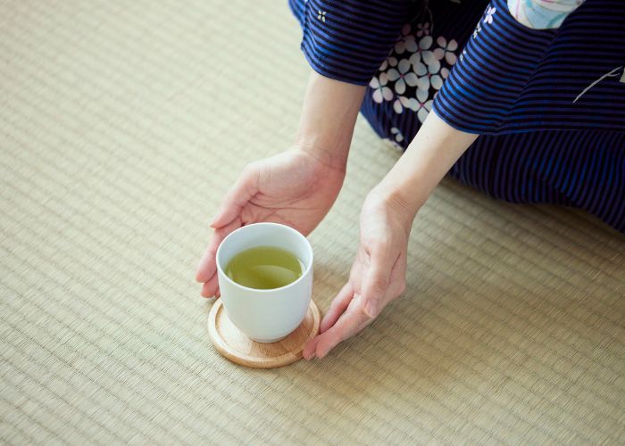 Hands Holding A Cup Of Japanese Green Tea