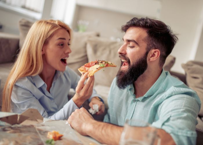 Couple Sharing Pizza At Home During A Cozy Date Night