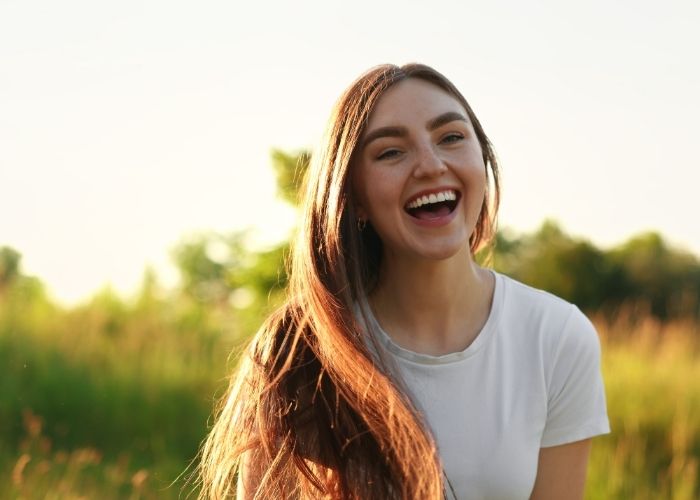 Smiling Woman Enjoying Time Outdoors And Feeling Happy On Her Own.