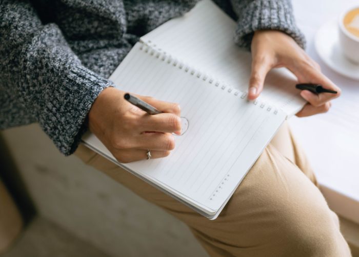 Woman Draws Something On A Textbook
