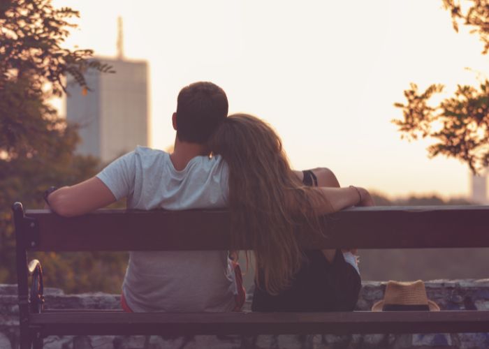 Couple In Love Sitting On Park Bench