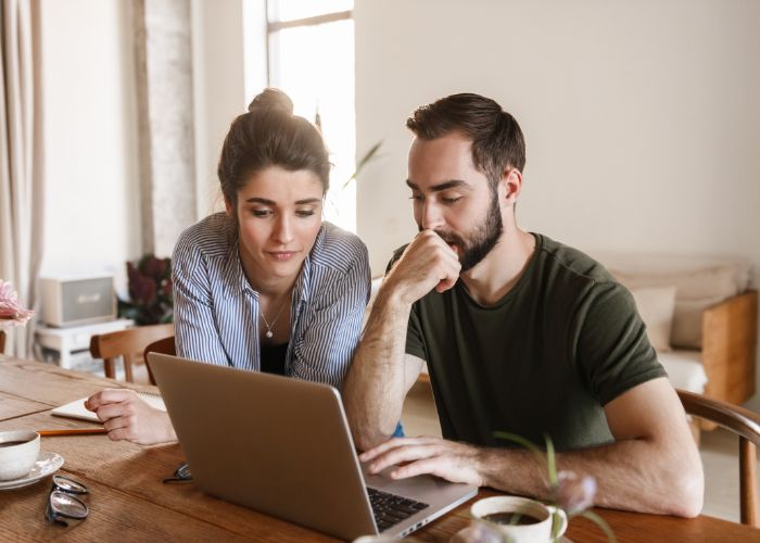Concentrated Brunette Couple Working On Laptop Together