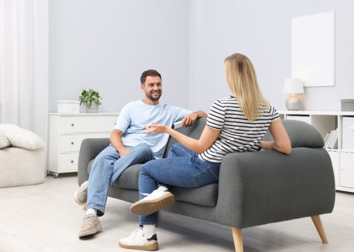 Couple Talking At Home On Sofa
