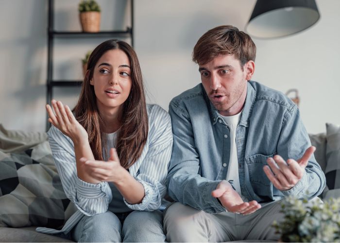 Couple On Couch Having An Emotional Discussion