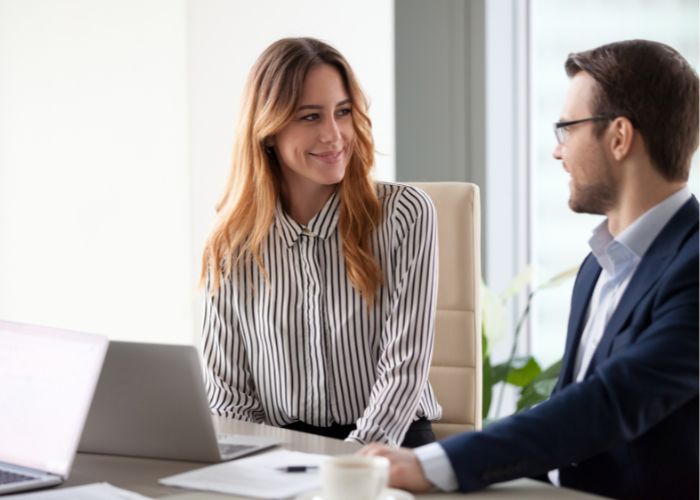 Smiling Colleagues Talk Laughing During Business Meeting